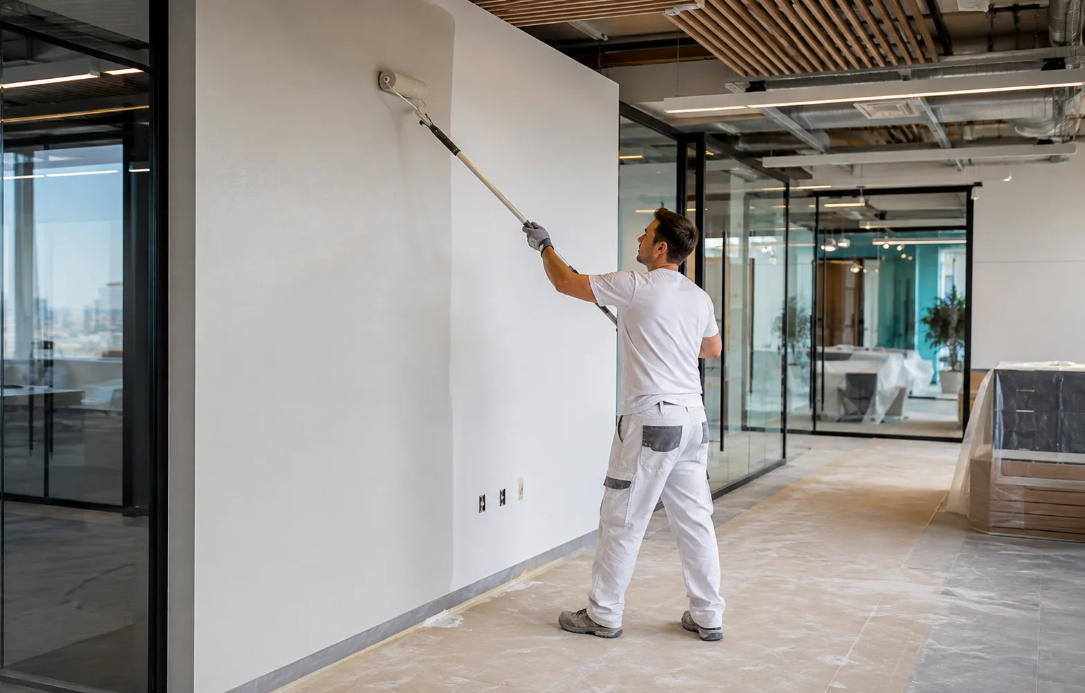 Commercial painter applying a clean finish inside a modern office fit-out